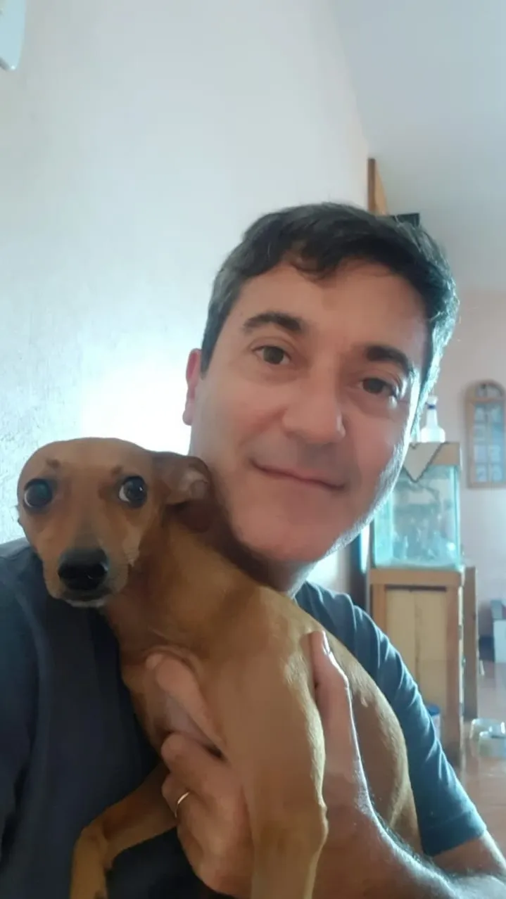 Tutor com cachorro de pelo caramelo no colo